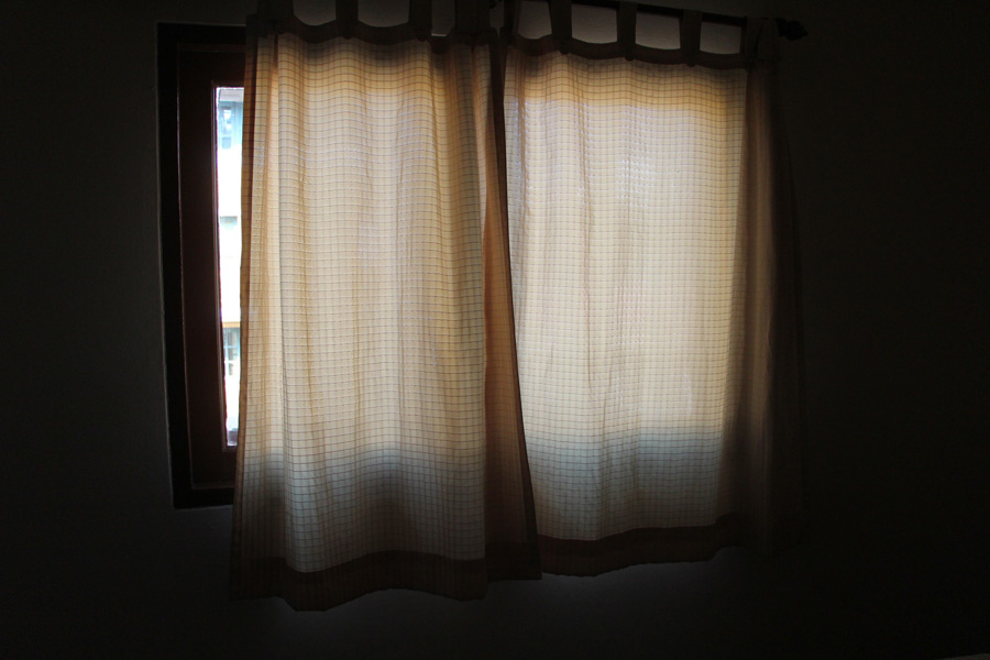 Les "rideaux" de la fenêtre aux vitres en carton. 